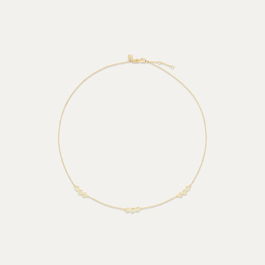 Gold necklace on a light beige background