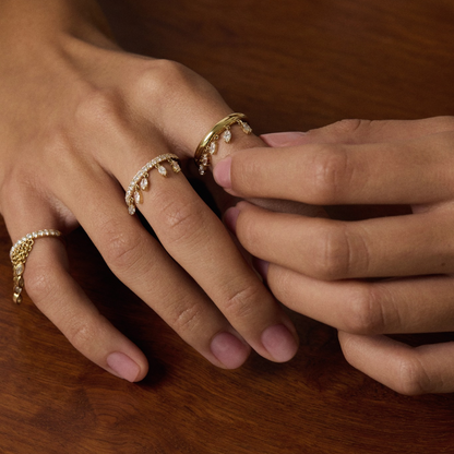 Close-up of hands with gold rings on a wooden surface