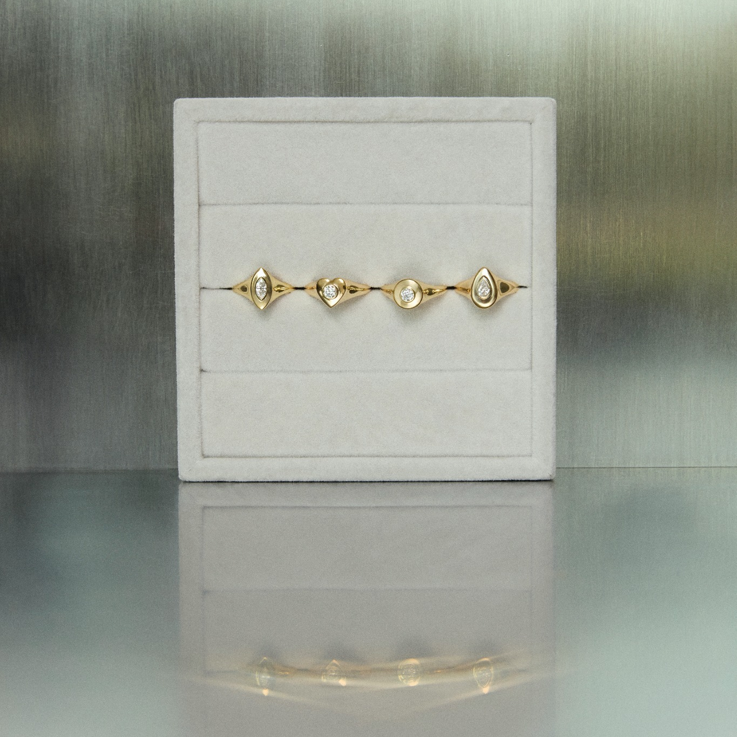 Gold bracelet on a white jewelry box with a blurred background
