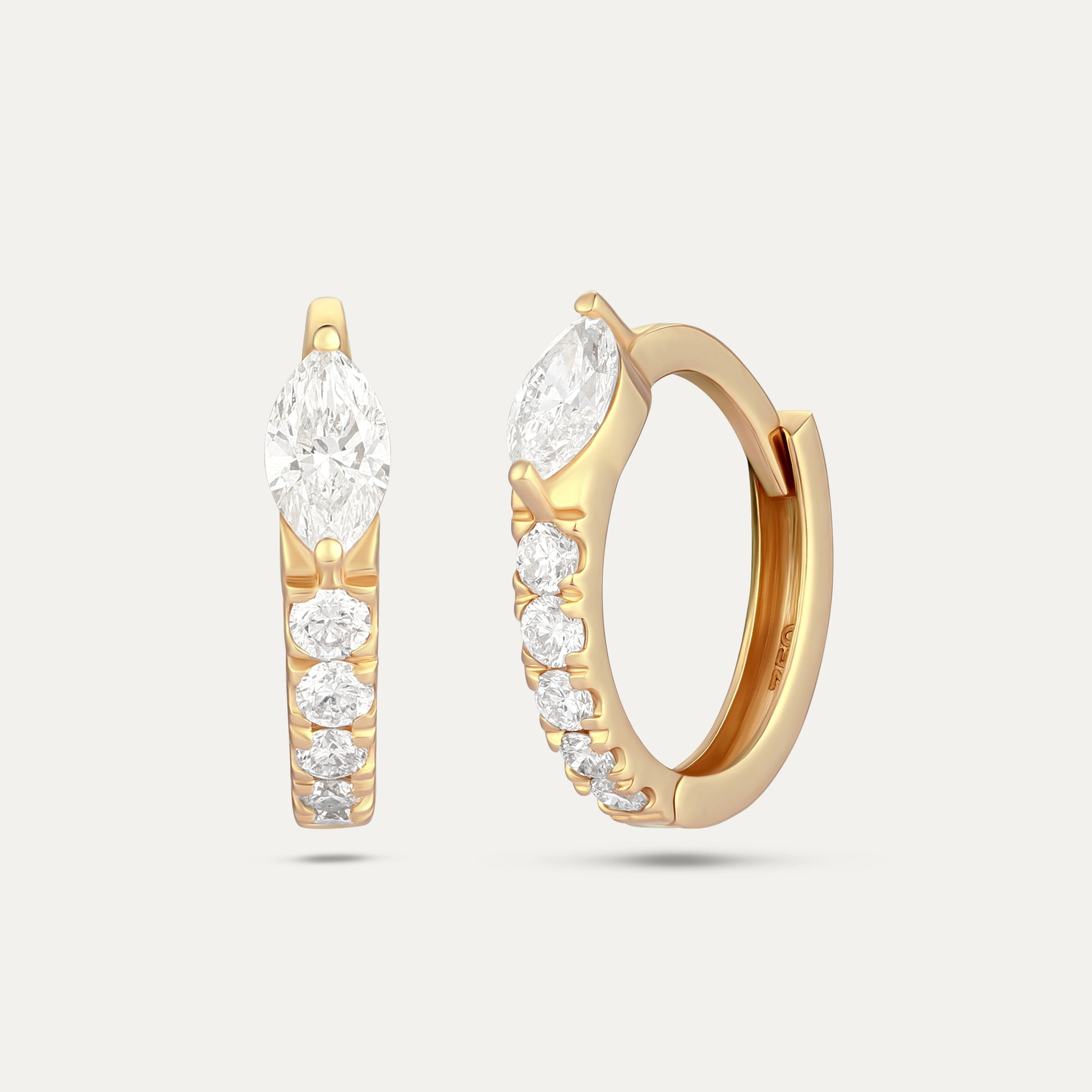 Gold hoop earrings with diamond accents on a light gray background