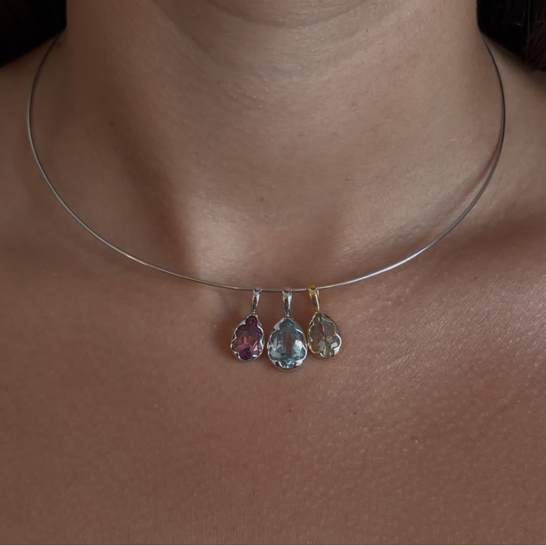 Necklace with three teardrop-shaped gemstones worn by a person