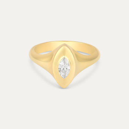 Gold ring with a marquise-shaped diamond on a light gray background