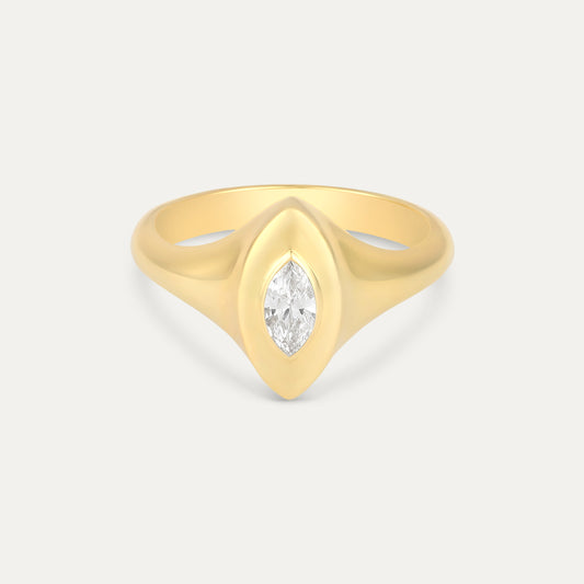 Gold ring with a marquise-shaped diamond on a light gray background