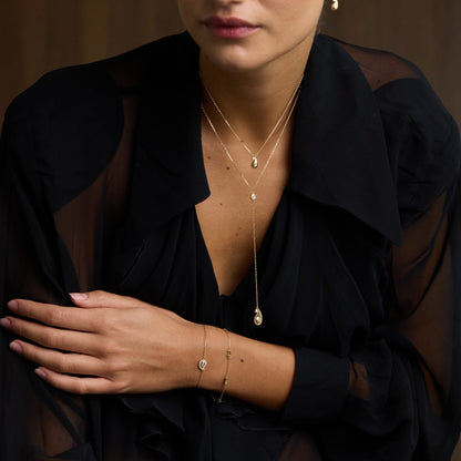 Woman wearing a black sheer top with visible jewelry against a brown background