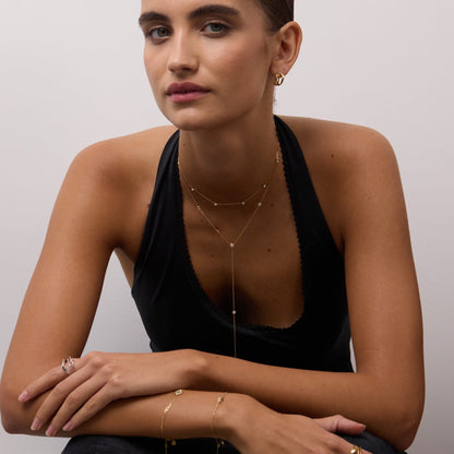 Woman wearing gold jewelry against a plain background