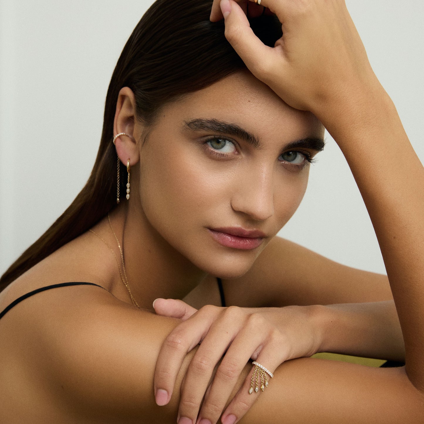 Woman with jewelry posing against a neutral background