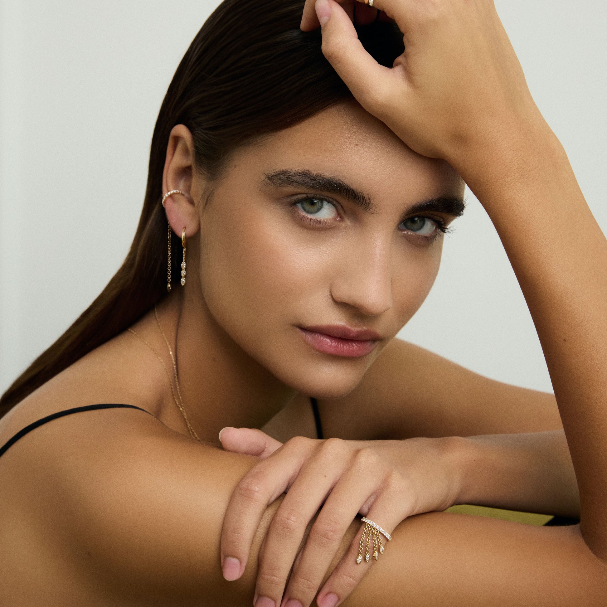 Woman with jewelry posing against a neutral background
