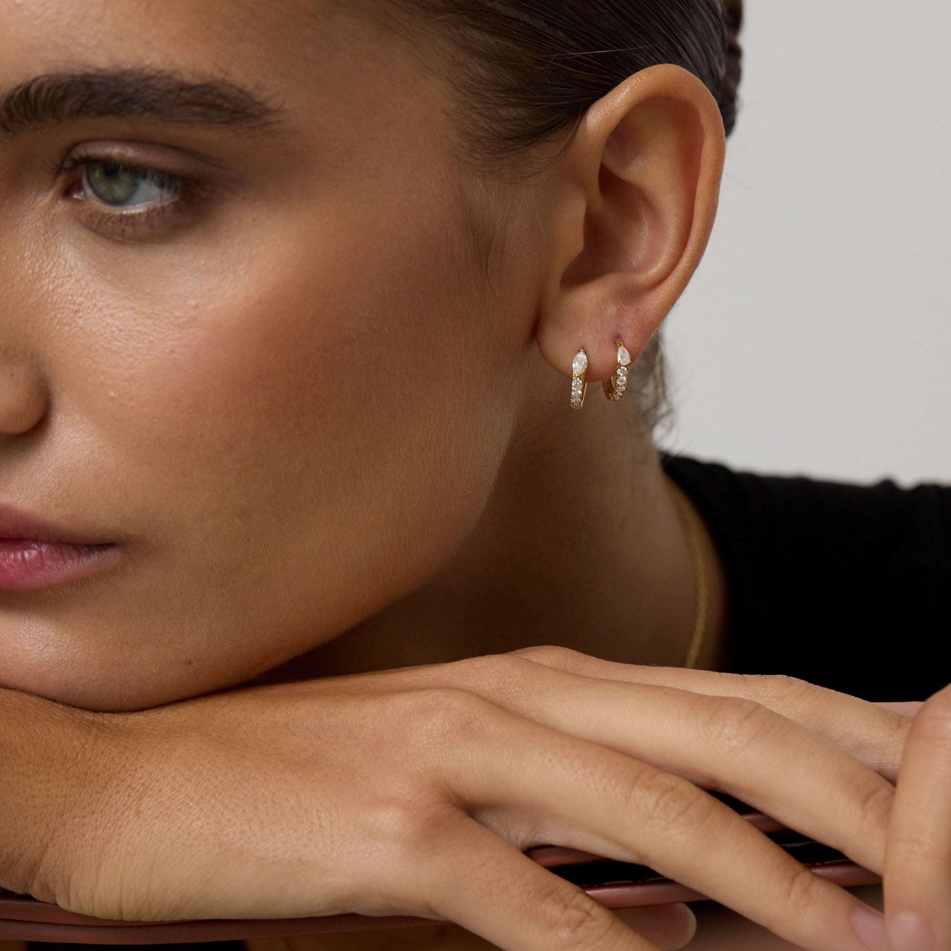 Close-up of a woman wearing earrings with a neutral background